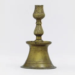 An Ottoman brass candlestick, the neck with incised arabesque decoration rising into the shape of a tulip
