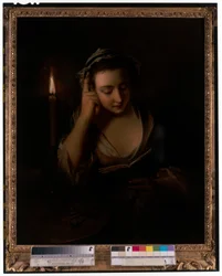 A young girl reading by candlelight