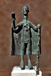 Nuragic culture: bronze statuette of traveller holding a stick and covered with a cape. Cagliari, Museo Nazionale Archeologico, Sardinia, Italy