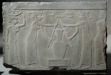 Low limestone relief representing women pressing lily flowers to extract the essence called “lirinon extraction” around 500-400 BC (Egyptian antiquity)