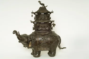 Figure of an elephant wearing a howdah cloth, elaborate surcingle and a pagoda building