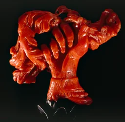 Hand with scroll: small object in coral