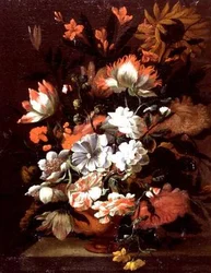 Tulips, carnations, sunflowers and other flowers in an urn on a stone ledge