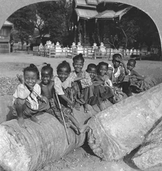 Burmese Children Sitting on a Palm Log, Burma