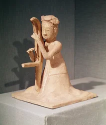 Seated musician playing a harp