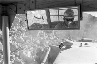 Heavy equipment operator in cab at Open pit copper mine Morenci mine for Phelps Dodge