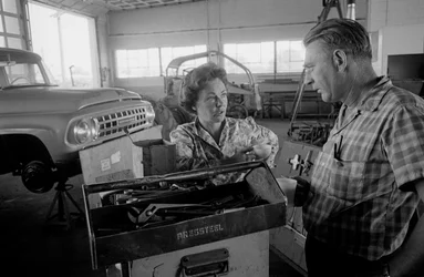 Truck driver Mildred Cooper chats with mechanic in a garage