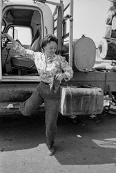 Woman truck driver Mildred Cooper steps out of the cab of her logging truck