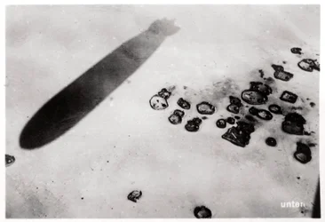 Aerial view of a desert settlement, with a shadow cast by a Zeppelin, 1931 1933