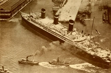 An Aerial Photograph of the Leviathan Being Towed by Small Tugs into Her Dock at New York