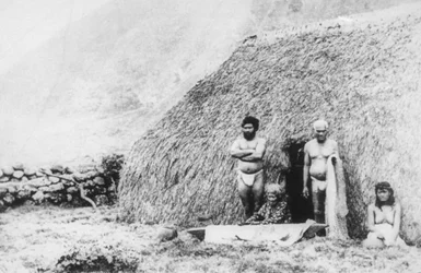 An Old Woman Beating Tapa in Front of a Pili Grass House, Kalaupapa, Hawaii