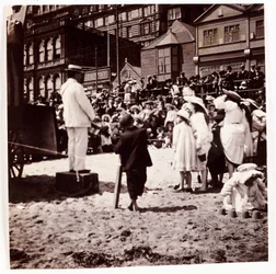 Crowd watching a beach entertainer, c 1905