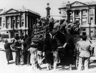French street sellers offering souvenirs to a truckload of German soldiers, Paris, 27 July 1940