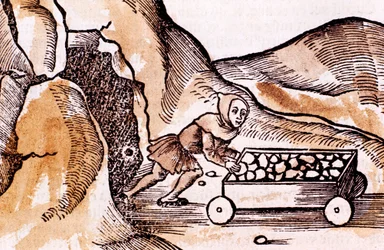 Miner pushing a trolley from a mine entrance