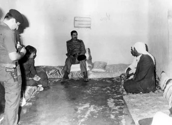 Saddam Hussein Visiting a Peasant House in Basra, Iraq
