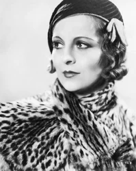 A stylish young woman wearing a hat and a fur coat, England 1933