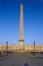 France, Paris, Obelisk of Luxor at the Place de la Concorde, Egyptian obelisk towering over a building covered in gilded hieroglyphic engravings.