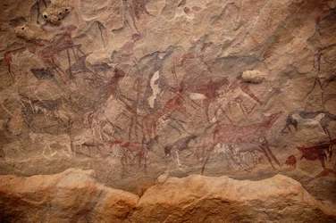 Rock art, Prehistory: Rock painting of a group of cattle and polychrome characters in an ornate shelter, in the Uweinat massif, Sudan. Period from 8000 to 3000 years BC. Photography