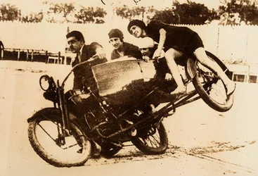 Man Driving a Motorcycle with a Sidecar Carrying Three Young Women
