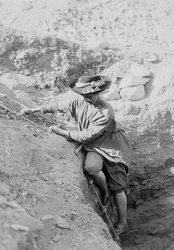 Hilda Petrie (née Urlin) descending by rope ladder into a tomb shaft, Possibly at Denderah