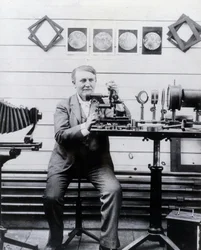 Photo of Thomas Alva Edison in front of his phonograph