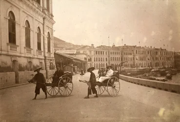 Two men carried by rickshaw in Hong Kong