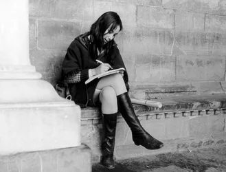 Young woman writing under the Loggia del Lanzi in Florence