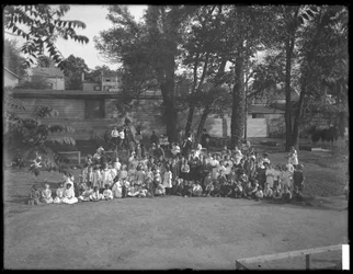 Large group of children assembled for a group portrait in an unidentified playground, c.1910
