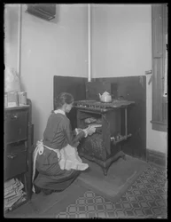 Miss Bates taking bread from the oven
