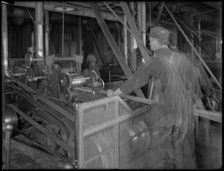 Worker feeding lumber into a planer, Oneida, New York, April 3, 1916