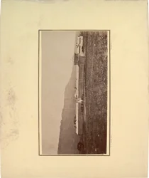 View of a stockade with several men gathered at entrance gate, 1871