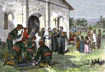 Spanish mission to California, with priests, soldiers and Indians of America praying before the Church in the 18th century
