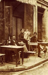Man holding a bottle of absinthe, c 1900, on a cafe terrace
